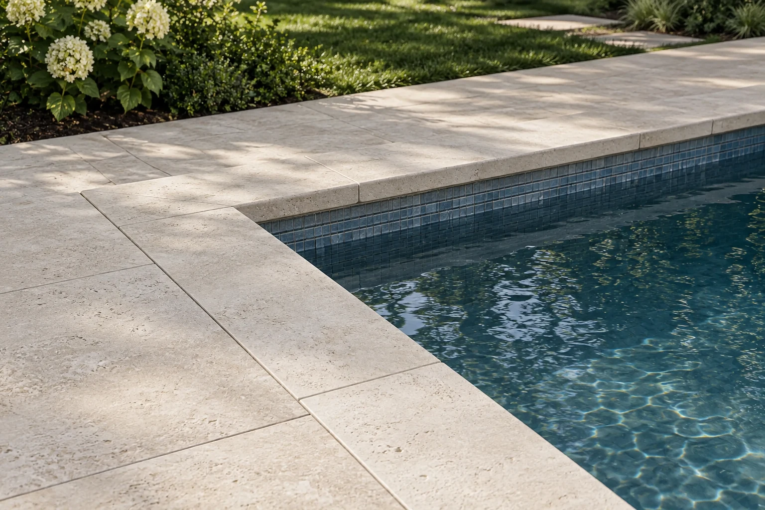 Alternate view of cream stone paving and coping beside a residential pool